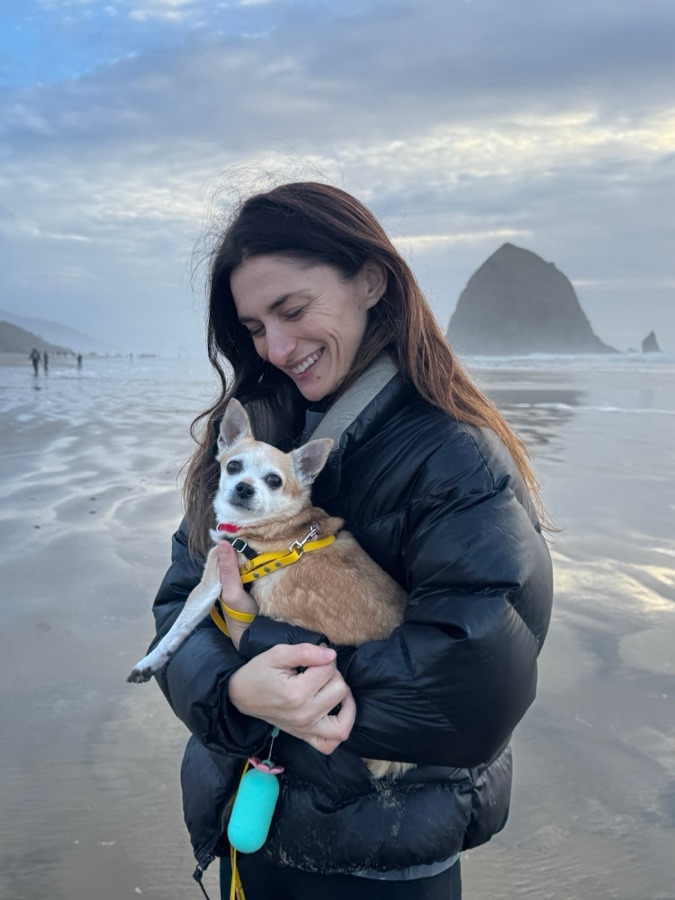 An owner holding her dog on the beach